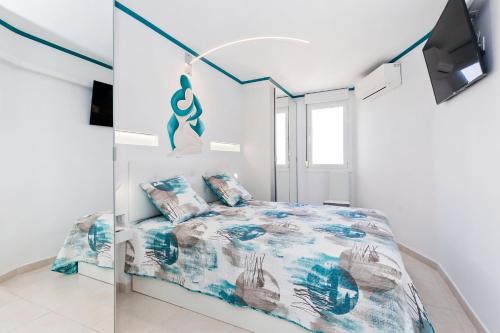 biała sypialnia z łóżkiem i telewizorem w obiekcie First line sea, luxury penthouse, sea and sunset view Vivenda Vacational Guayero 618 w mieście Los Cristianos