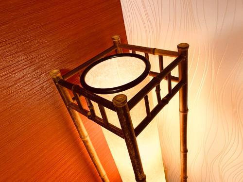 a mirror on a stand next to a wall at ⑳都宿 松 in Osaka
