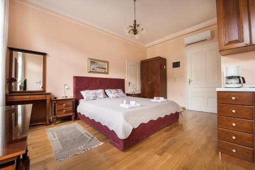 a bedroom with a bed and a dresser at Apartments Villa Devana in Opatija