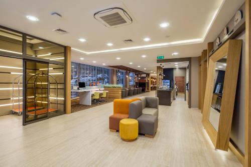 an office lobby with a couch and a chair at Holiday Inn Antalya - Lara by IHG in Antalya