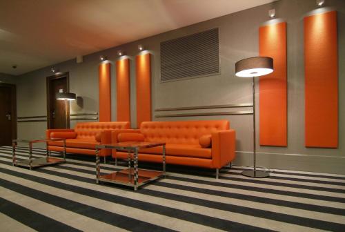 a waiting room with orange couches and a table at Holiday Inn Bydgoszcz, an IHG Hotel in Bydgoszcz