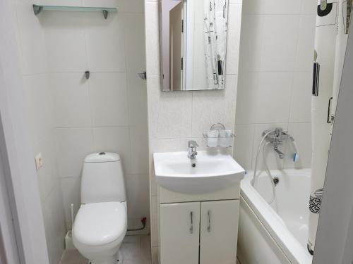 biała łazienka z toaletą i umywalką w obiekcie ismail 88 w Kiszyniowie