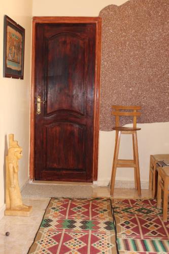 a wooden door in a room with a stool and a rug at Pyramids Overlook Inn in Cairo