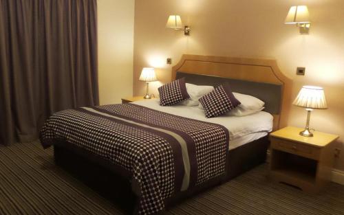 um quarto de hotel com uma cama grande com duas almofadas em Parkside International Hotel em Reading