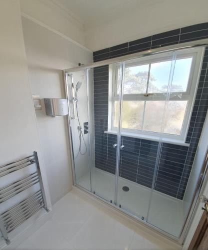 a shower stall in a bathroom with a window at Clarence House Shanklin in Shanklin
