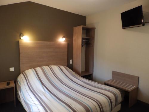 Schlafzimmer mit einem Bett und einem Flachbild-TV in der Unterkunft Logis Hôtel Restaurant Les Cévennes in Saint-Cirgues-en-Montagne