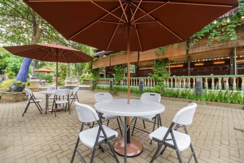 a group of tables with white chairs and umbrellas at RedDoorz Plus @ Setiabudi Medan 4 in Sunggal