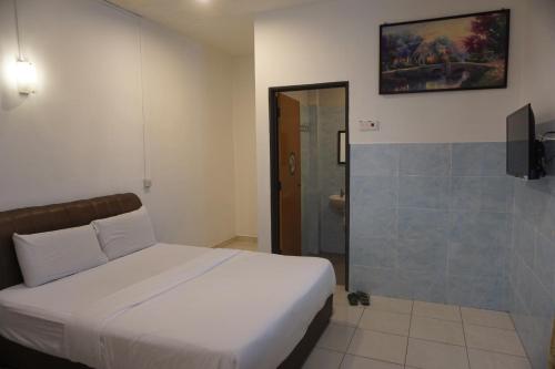 a bedroom with a white bed and a shower at S & S Guest House Kuantan in Kuantan