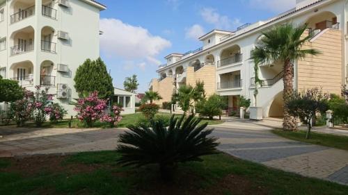 a large white building with a palm tree in front of it at Sapphire L44 in Iskele