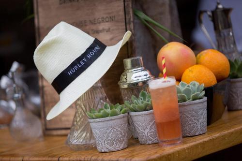 a table topped with potted plants with a hat and a drink at Hurley House Hotel in Hurley