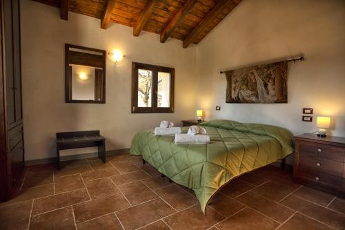 a bedroom with a green bed with towels on it at Villa Viktoria & Andras in Tredozio
