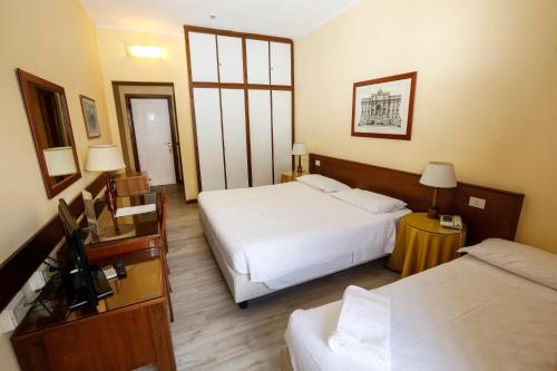 a hotel room with two beds and a television at Hotel Giardino d'Europa in Rome