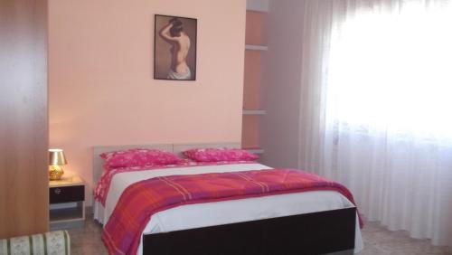 una camera da letto con un letto con cuscini rosa e una finestra di Il campanile a Soleto