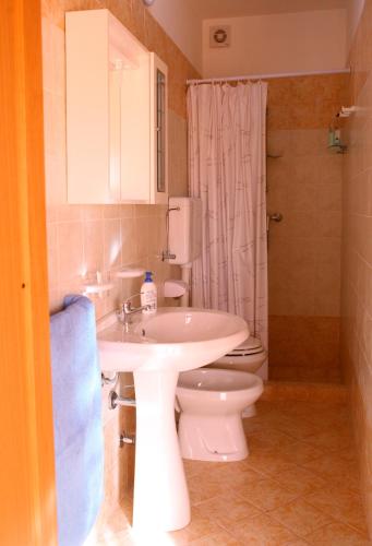 a bathroom with a white sink and a toilet at Il campanile in Soleto