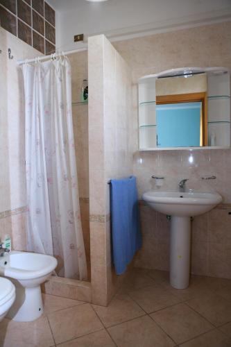 bagno con lavandino, servizi igienici e specchio di Il campanile a Soleto