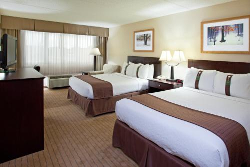 a hotel room with two beds and a flat screen tv at Holiday Inn Canton-Belden Village by IHG in Canton