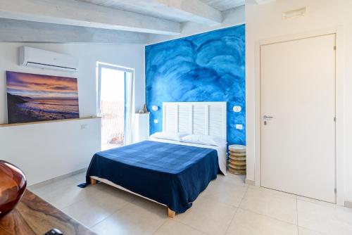 a blue bedroom with a bed and a painting on the wall at B&B Il Colore del mare in Agropoli