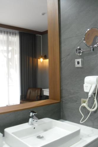 La salle de bains est pourvue d'un lavabo et d'un miroir. dans l'établissement Sturgis Boutique Hotel Cipanas, à Cianjur