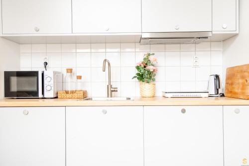 a kitchen counter with a sink and a microwave at Pieni Roobertinkatu Small 13 in Helsinki