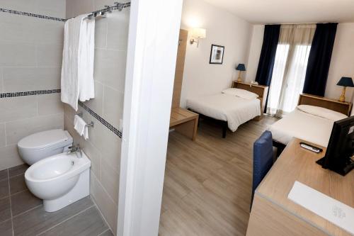 a bathroom with a toilet and two beds in it at Hotel Giardino d'Europa in Rome