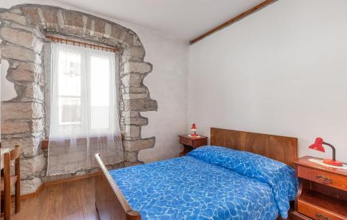 een slaapkamer met een blauw bed en een stenen muur bij Bruna in Poreč
