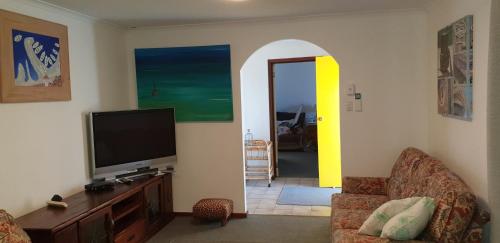 a living room with a flat screen tv and a living room at Mermaid Beachside Accommodation in Denham
