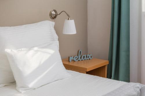 a bed with a white pillow and a lamp on a table at Lavica Seaside Apartments, Podstrana in Podstrana