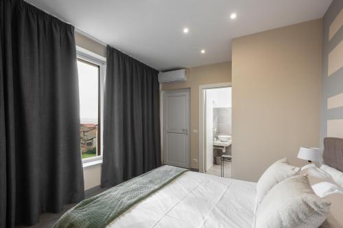 a bedroom with a bed and a large window at VIVERONE LAKE ROOMS in Viverone
