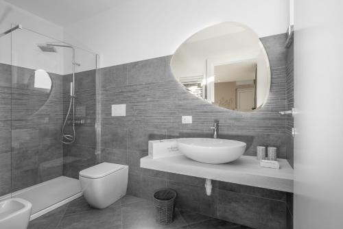 a bathroom with a sink and a toilet and a mirror at VIVERONE LAKE ROOMS in Viverone
