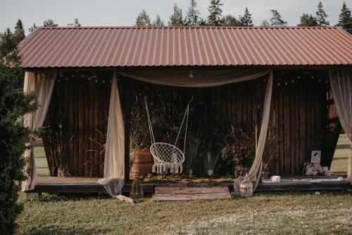 a gazebo with a white chair in it at Viesu nams RŪĶĪŠI in Rugāji