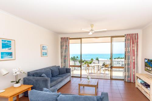 a living room with a couch and a view of the ocean at OCEAN VIEWS 10 in Airlie Beach