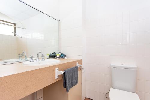 a bathroom with a sink and a toilet and a mirror at OCEAN VIEWS 10 in Airlie Beach