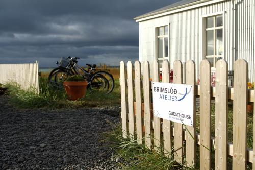 a fence with a sign on it next to a building at Brimslóð Atelier Guesthouse in Blönduós