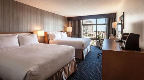 a hotel room with two beds and a desk at Holiday Inn Chicago North-Evanston by IHG in Evanston