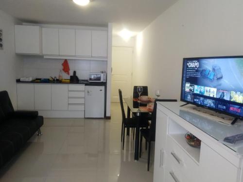 a kitchen and a living room with a flat screen tv at Aras Century Tower in Montevideo