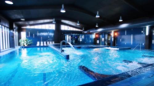 a large indoor swimming pool in a building at Hotel Termy Pałacowe in Nałęczów