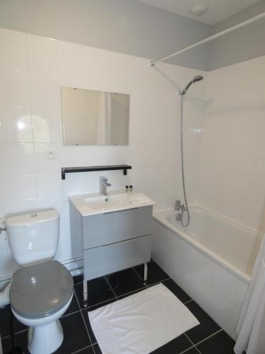 a bathroom with a toilet and a sink and a tub at Hôtel Restaurant le clos de l 'Ancien Pressoir in Commes