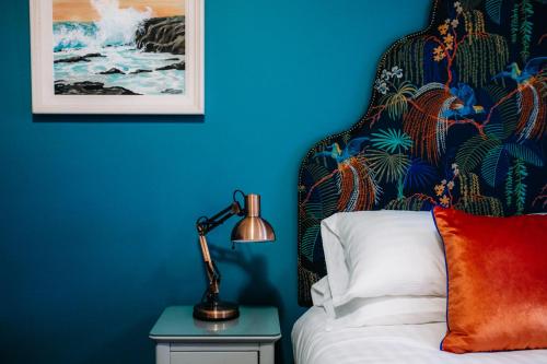 um quarto azul com uma cama com uma almofada vermelha e um candeeiro em Ralph's em Moira