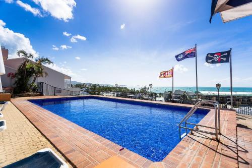 a swimming pool with flags on top of a building at OCEAN VIEWS 10 in Airlie Beach