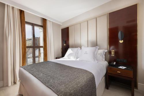 Un dormitorio con una cama grande y una ventana en Suites Center Barcelona, en Barcelona