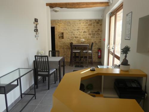 a living room with a yellow table and chairs at Hôtel Restaurant le clos de l 'Ancien Pressoir in Commes