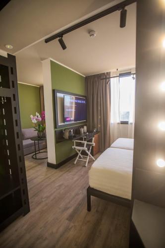a hotel room with a bed and a tv at Mercure Roma Cinecittà in Rome