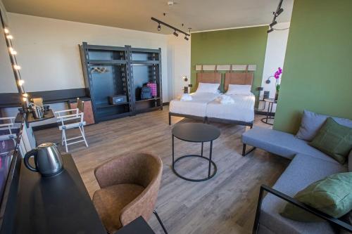 a bedroom with a bed and a couch and a table at Mercure Roma Cinecittà in Rome