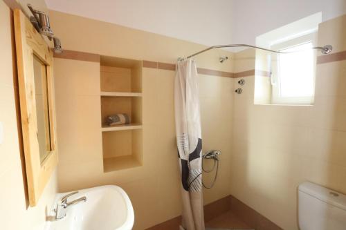 y baño con cortina de ducha y lavamanos. en Oasis Rooms & Studios in Galissas, en Galissas