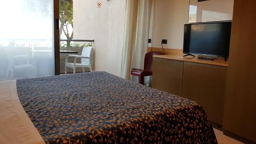 a hotel room with a bed and a flat screen tv at Addaura Village e Congressi in Mondello