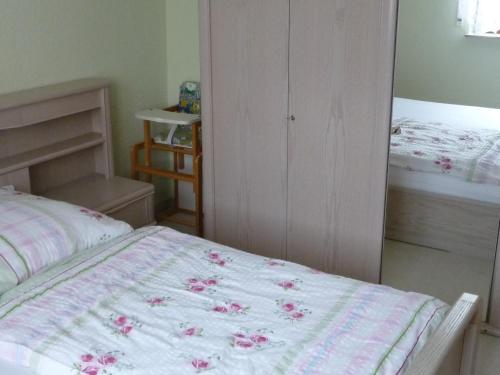 um quarto com uma cama com flores cor-de-rosa em Ferienwohnung Wilsdruff - Kaufbach em Wilsdruff