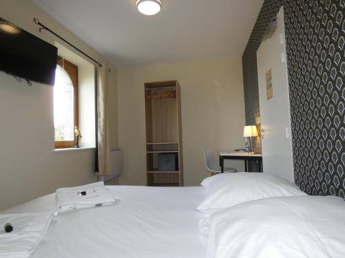a bedroom with a white bed and a window at Hôtel Restaurant le clos de l 'Ancien Pressoir in Commes