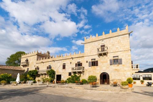 a large stone building with a blue sky at Hotel Pazo O Rial in Vilagarcia de Arousa