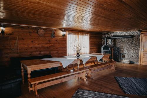 una sala da pranzo con pareti in legno e tavoli in legno di Viesu nams RŪĶĪŠI a Rugāji