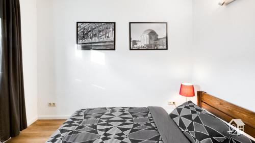 a bedroom with a bed and three pictures on the wall at Gästewohnung Köln-Longerich in Cologne